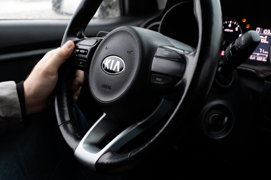 Kia-sedan-man-hand-on-steering-wheel