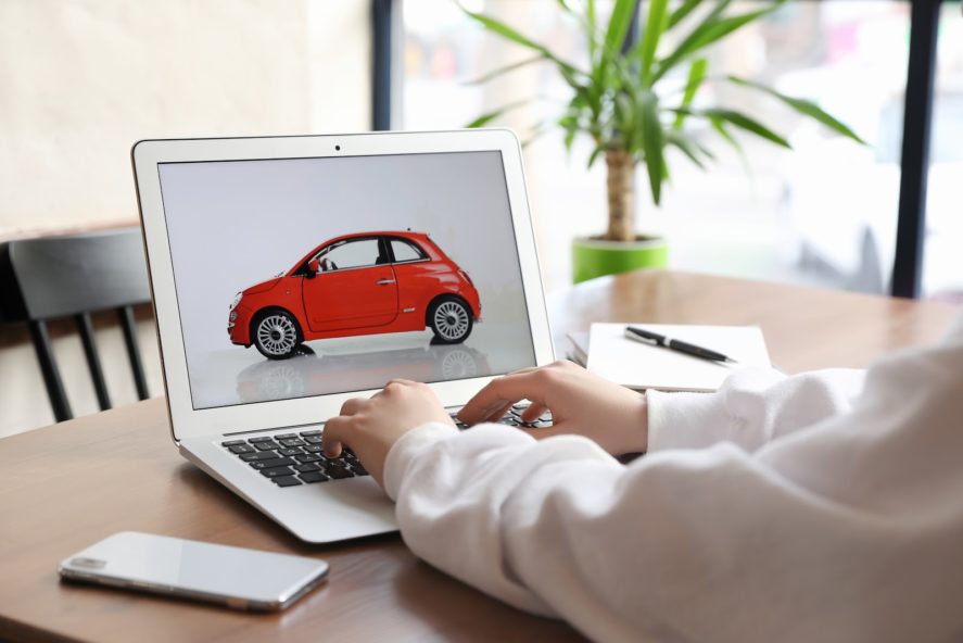 Woman-Using-Laptop-To-Buy-Car